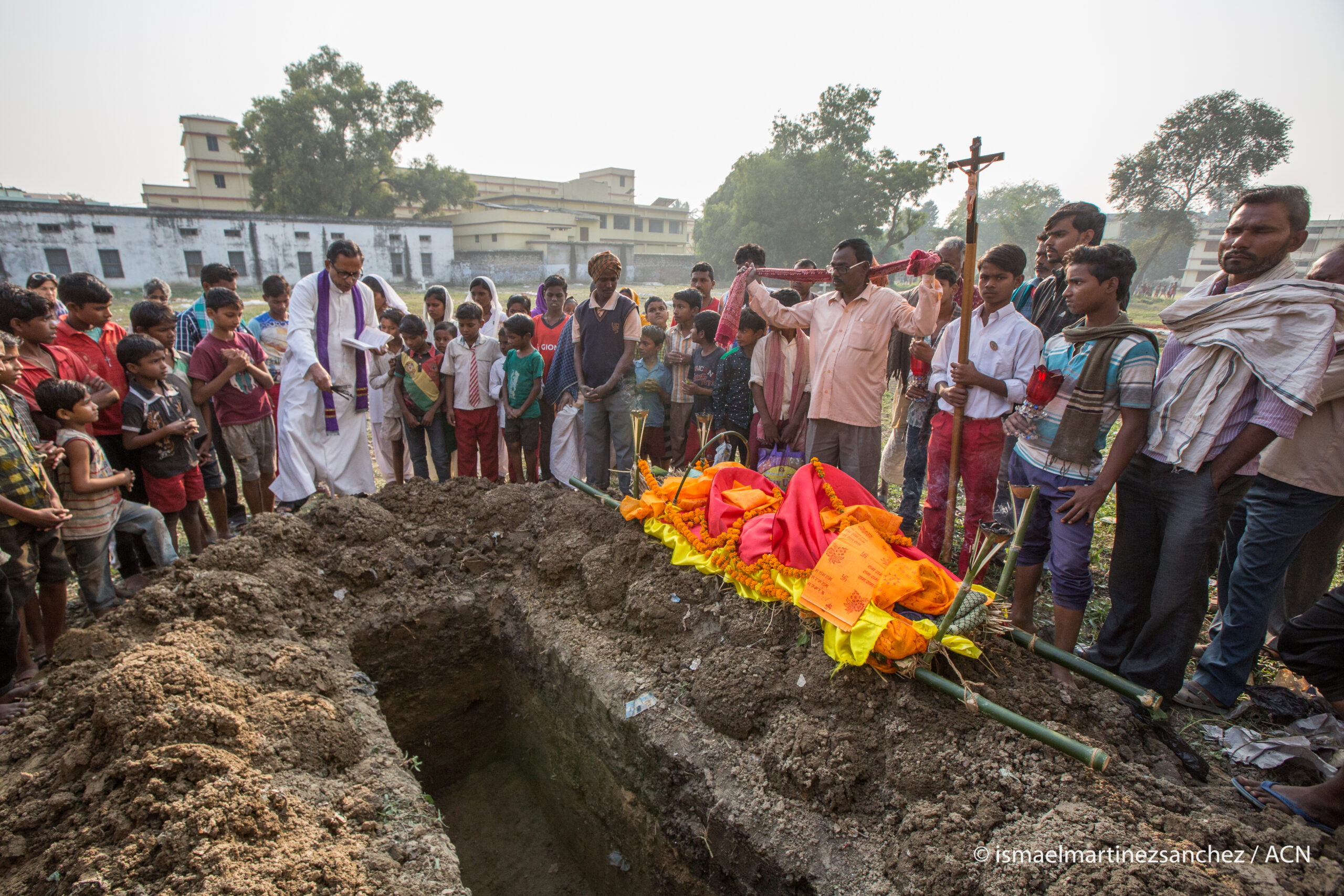 Il sacerdote segue il rito durante la cerimonia funebre cattolica nel cimitero, nello Stato del Bihar.